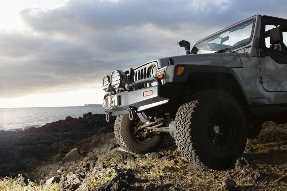 Low Angle View Of 4x4 On A Rocky Beach